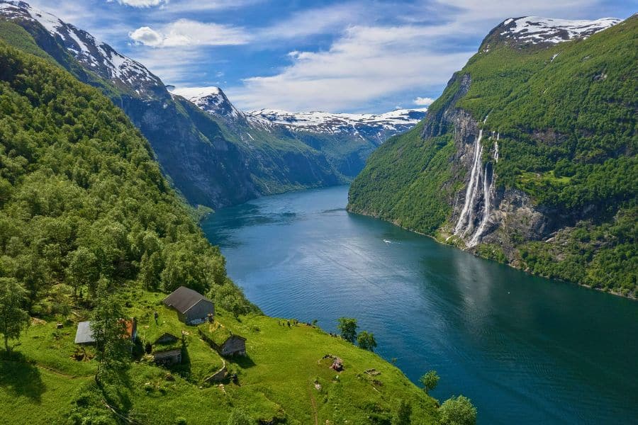 Aerial view of Geirangerfjord with Seven Sisters waterfall and snow-capped mountains in Norway