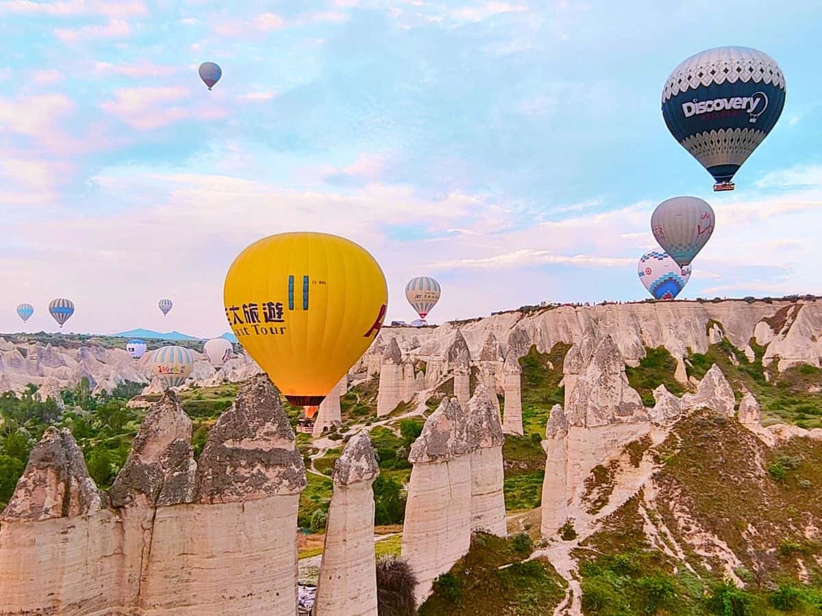 hot air balloons flying above fairy chimneys in love valley cappadocia