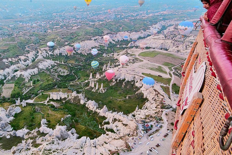 looking below at cappadocian landscape from a hot air ballloon basket 
