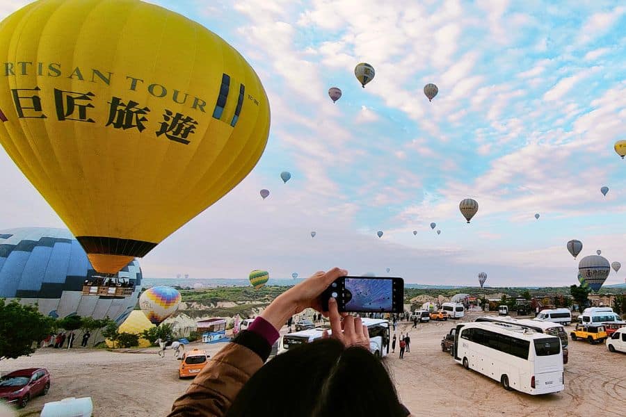visitors capturing and watching hot air balloons from love valley viewpoint