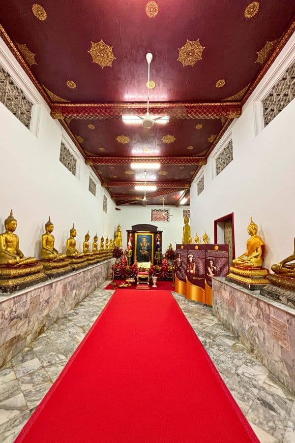 golden buddha statues seated in meditation poses in wat pho bangkok