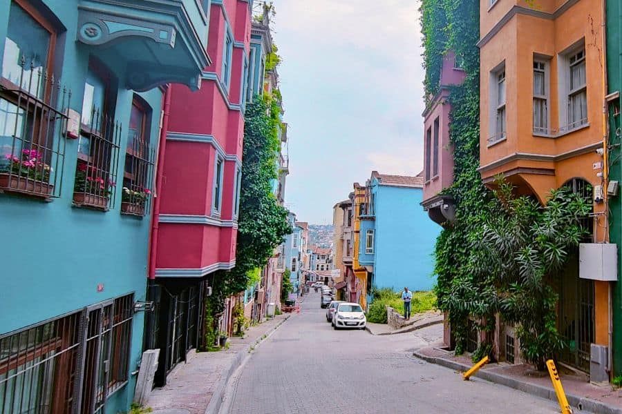 a street in Istanbul's fener-balat neighborhood lined with colorful, ivy-covered houses