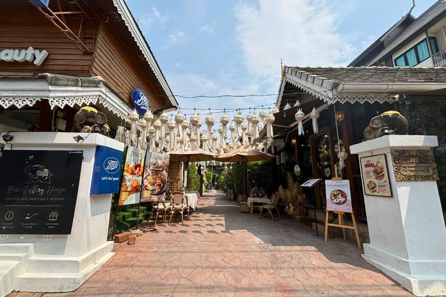 entrance of buri gallery house resort in chiang mai thailand showcasing traditional thai architecture and a series of white hanging lanterns 