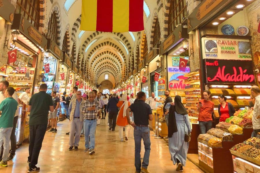 people shopping inside the bustling grand bazaar in beyazit neighborhood of istanbul surrounded by colorful shops and goods