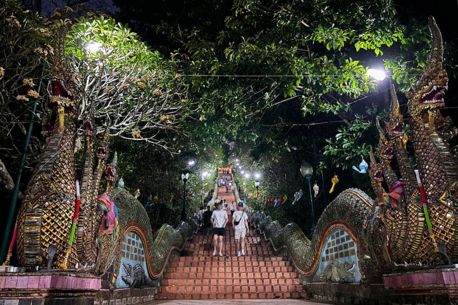 people climbing up and down the steps leading to doi suthep in chiang mai