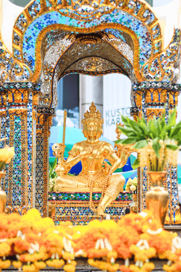 the golden statue of diety at erawan shrine in lumpini pathumwan