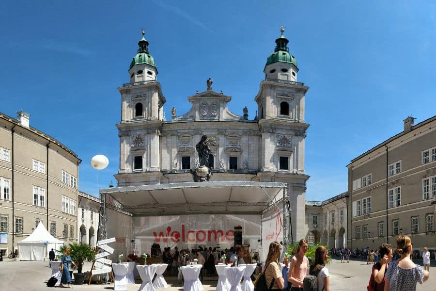 an event at the cathedral sqaure in salzburg with a statue of mary in the center hidden behind the event stage