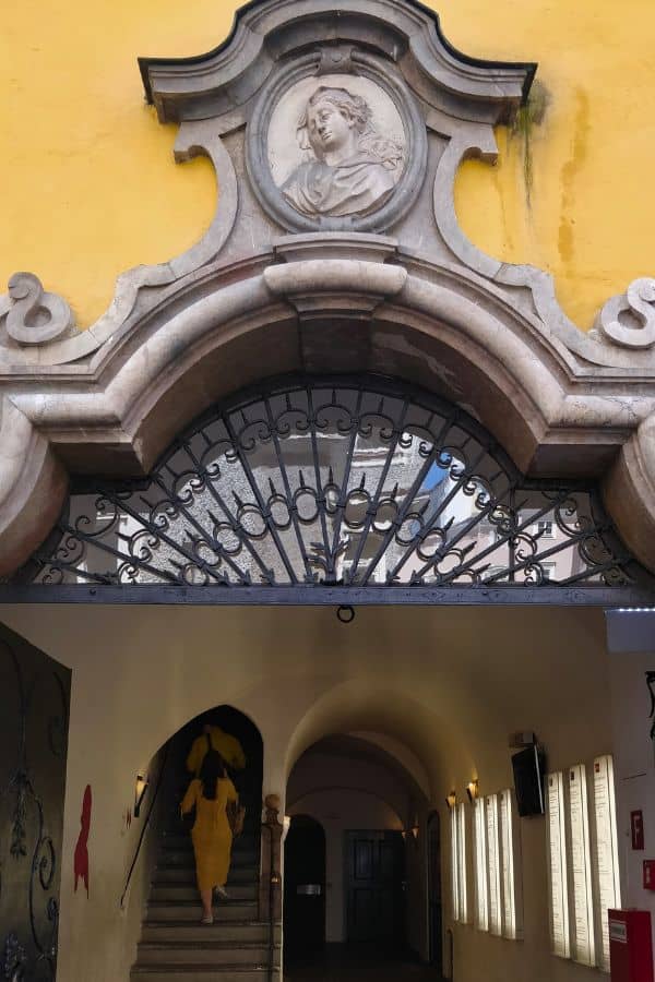 a lady climbing the steps to the museum at the mozarts birthplace entrance gate in salzburg
