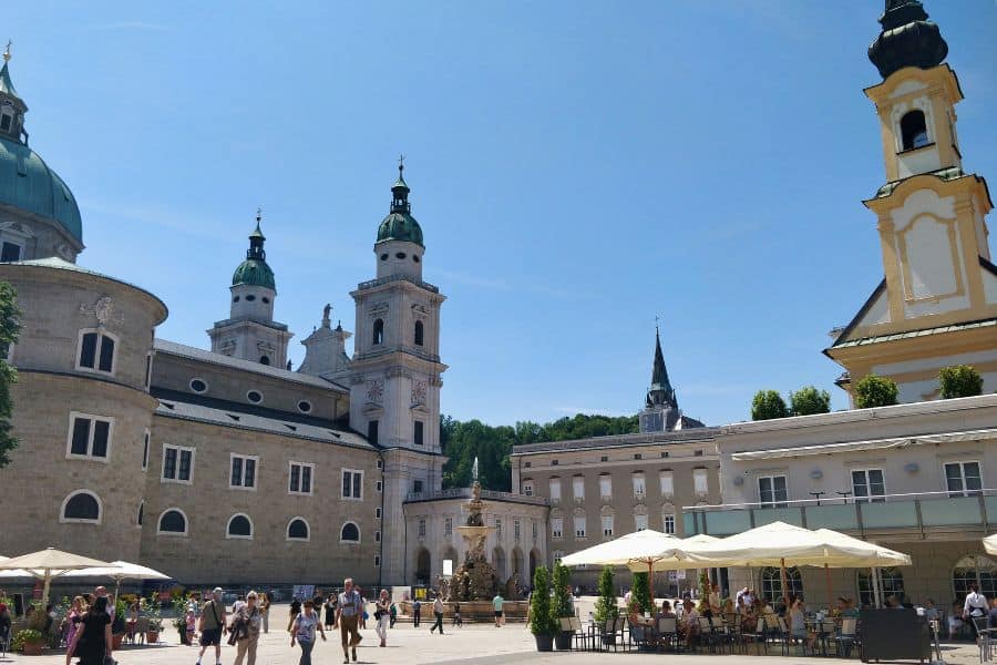 residenzplatz square with residence fountain surrounded by landmarks like old residence, new residence, salzburg cathedral, and a row of townhouses