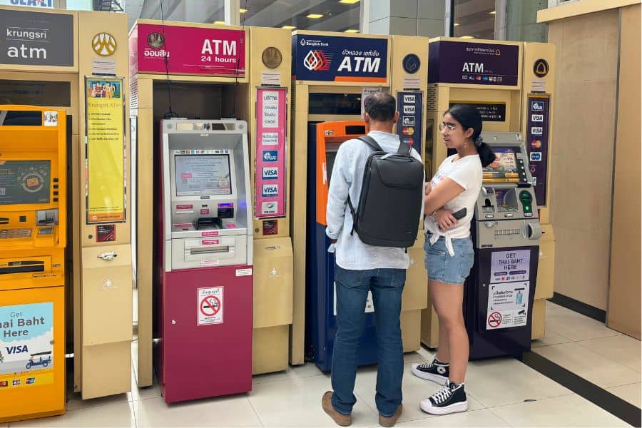 hubby and mini me using an atm in a mall in bangkok