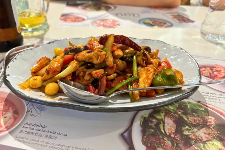 spicy stir-fried chicken with vegetables and cashews served on a plate in a thai restaurant at mbk mall in bangkok