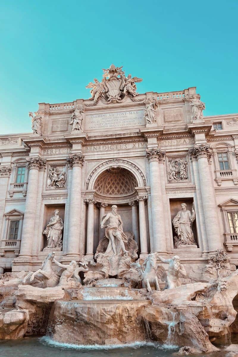  the ornate Trevi Fountain in Rome, Italy, featuring grand baroque architecture and sculptures of mythological figures with water cascading into the fountain pool