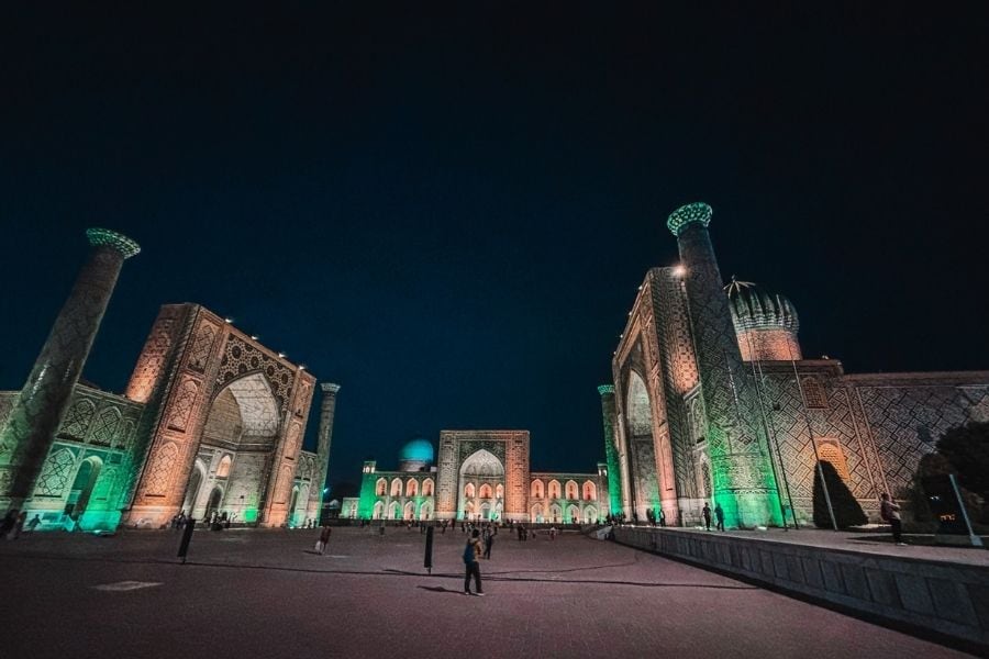 registan square in samarkand illuminated at night with historic madrasas and open courtyard