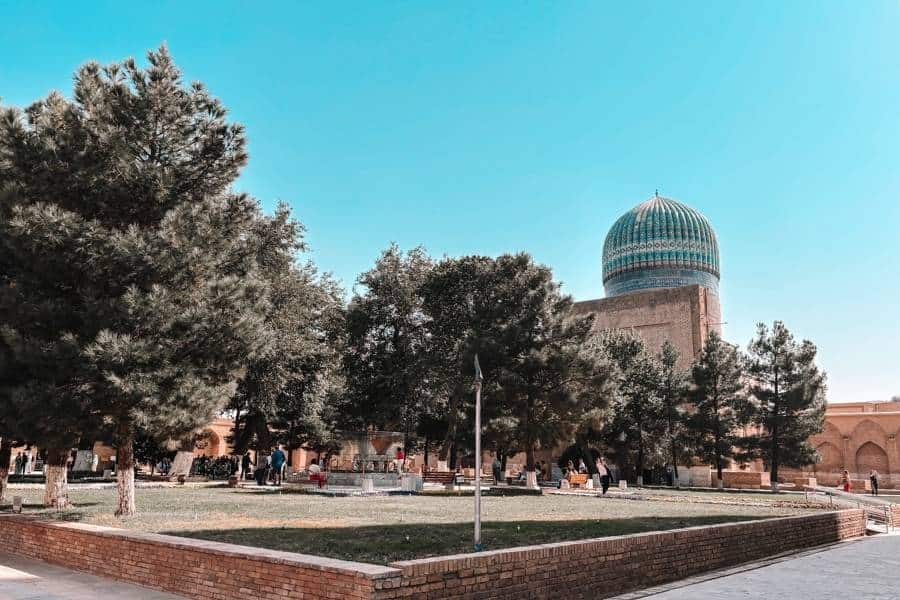 bibi khanym mosque courtyard with turquoise dome and trees in samarkand