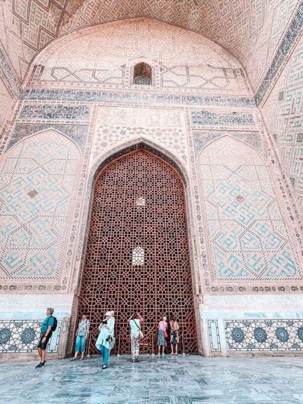 bibi khanym mosque interior iwan with carved wooden lattice and visitors