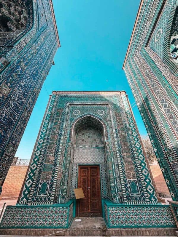 ornate turquoise tiled mausoleum at shakhi zinda ensemble in samarkand framed by richly decorated walls under a clear blue sky