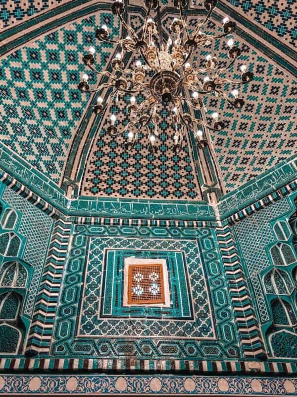 ornate chandelier hanging beneath tiled dome of the kusum ibn abbas mausoleum at shah i zinda samarkand