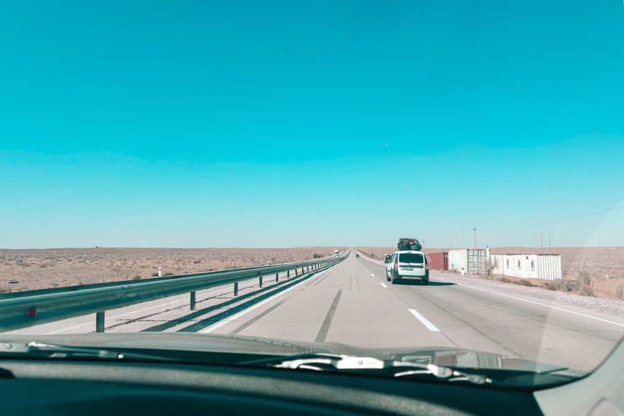 road trip from bukhara to khiva through uzbekistan desert highway with long straight road and sparse landscape