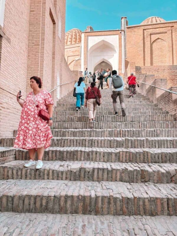 stone steps leading into shakhi zinda necropolis with visitors walking up