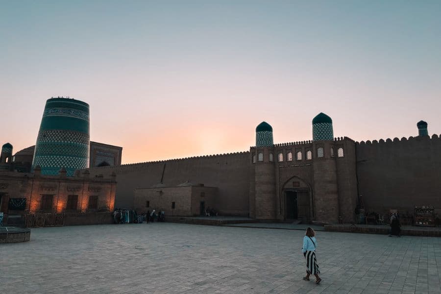 sunset view of itchan kala walls in khiva with west gate ata darwaza and kalta minor minaret in background