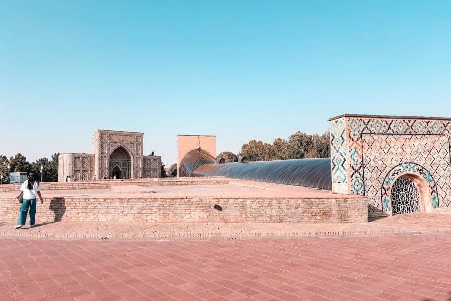 ulugh beg observatory ruins in samarkand with tiled entrance, brick platforms, and open courtyard under clear blue sky