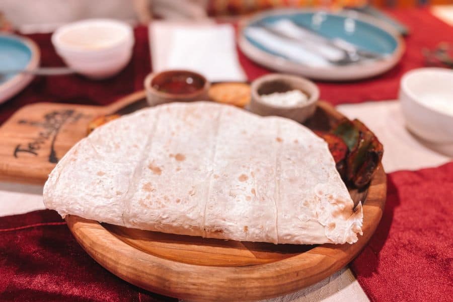uzbek lavash bread served at terrassa cafe khiva on wooden platter with sauces and grilled vegetables