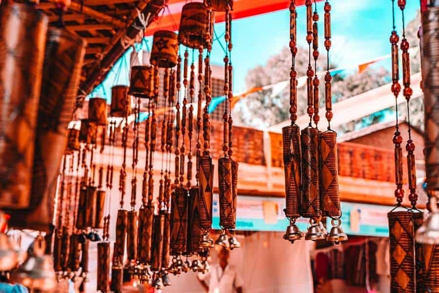 hanging bamboo wind chimes at a handicrafts stall in dilli haat under a vibrant sky