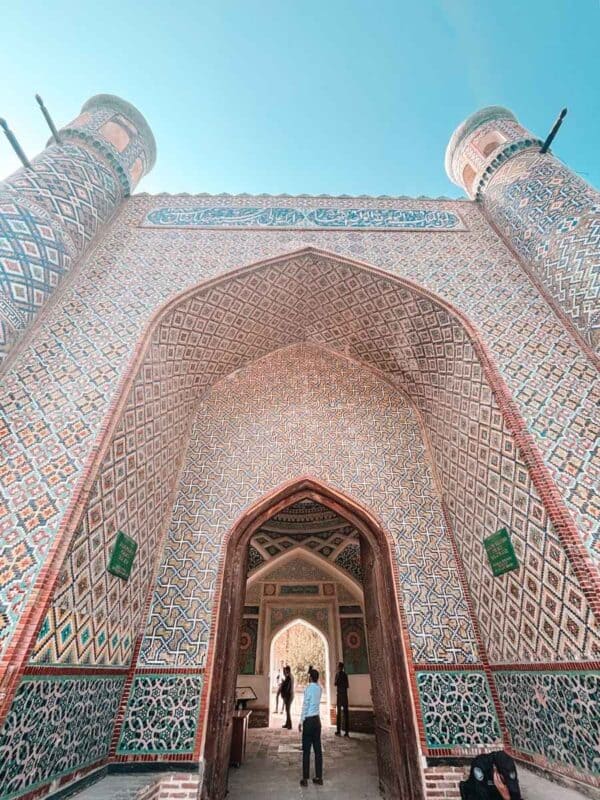 intricate tiled gateway of khudayar khan palace in kokand under a clear blue sky