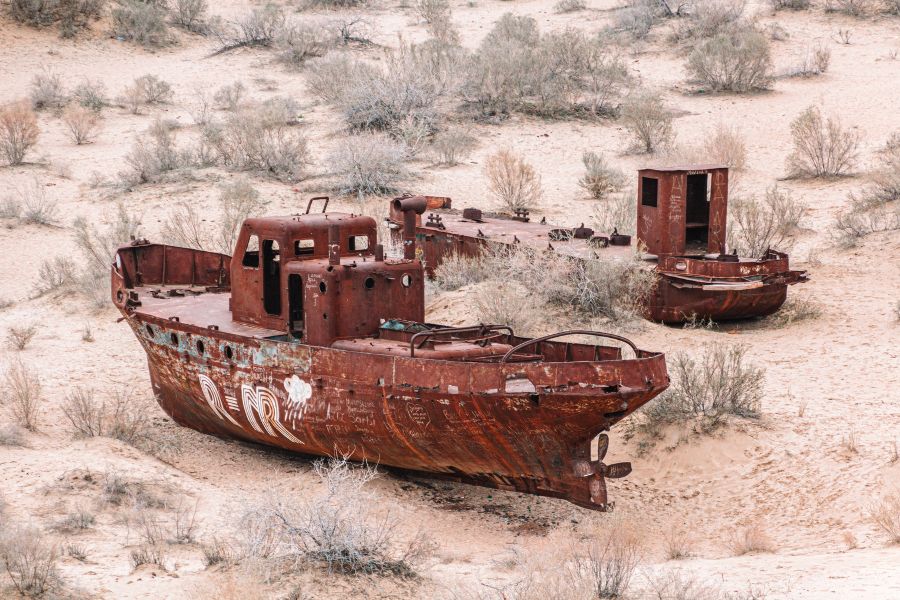 abandoned rusted fishing boats in the aral sea ship graveyard in muynak, uzbekistan