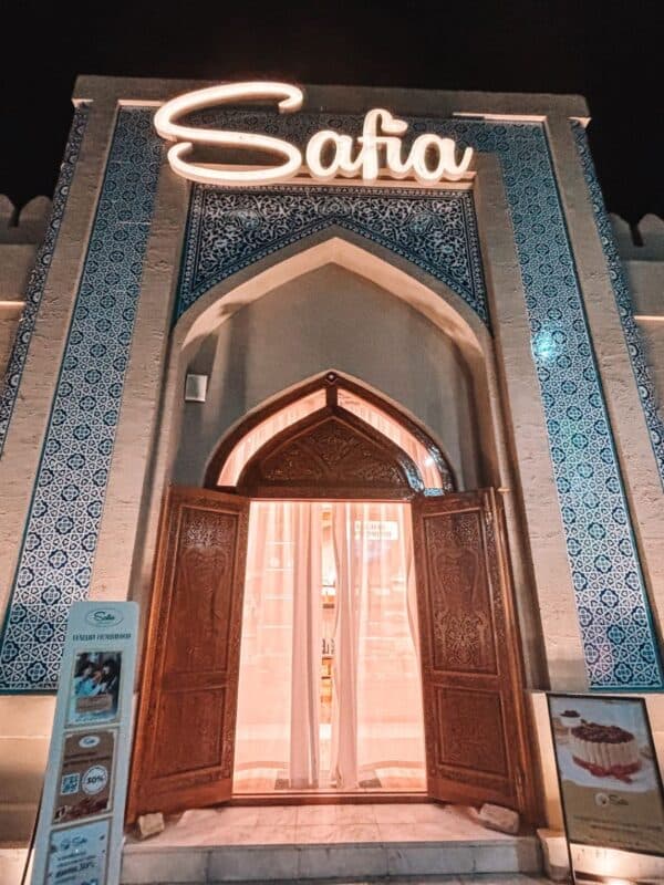 night view of safia restaurant entrance in khiva with blue tiled arch and wooden doors