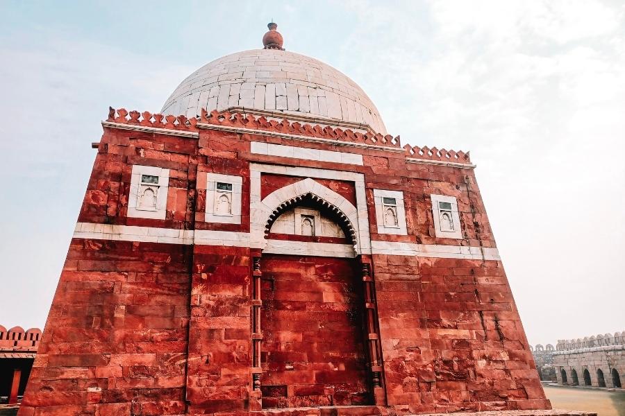tomb of ghiyas ud din tughlaq inside tughlaqabad fort, made of red sandstone with a white dome, delhi