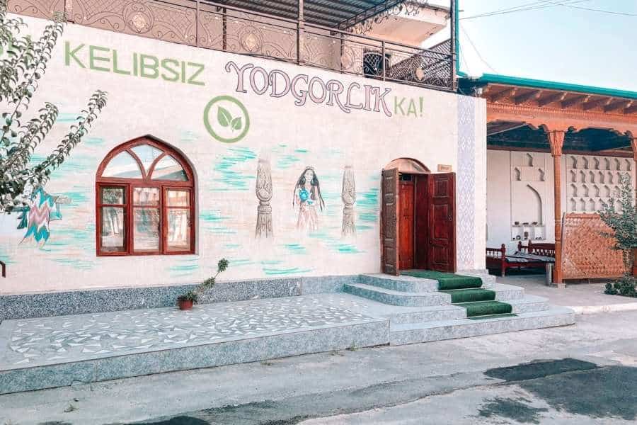 entrance of yodgorlik silk factory in margilan with murals and wooden door