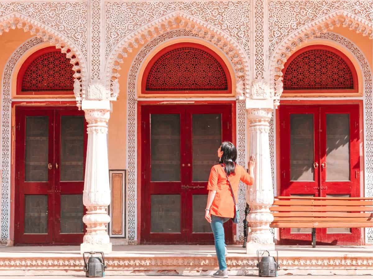 me, standing in front of ornate red doors at jaipur city palace india