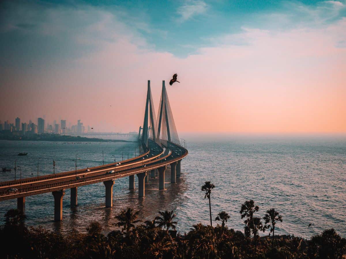 bandra worli sea link at sunset with cars over the arabian sea and mumbai skyline in the background