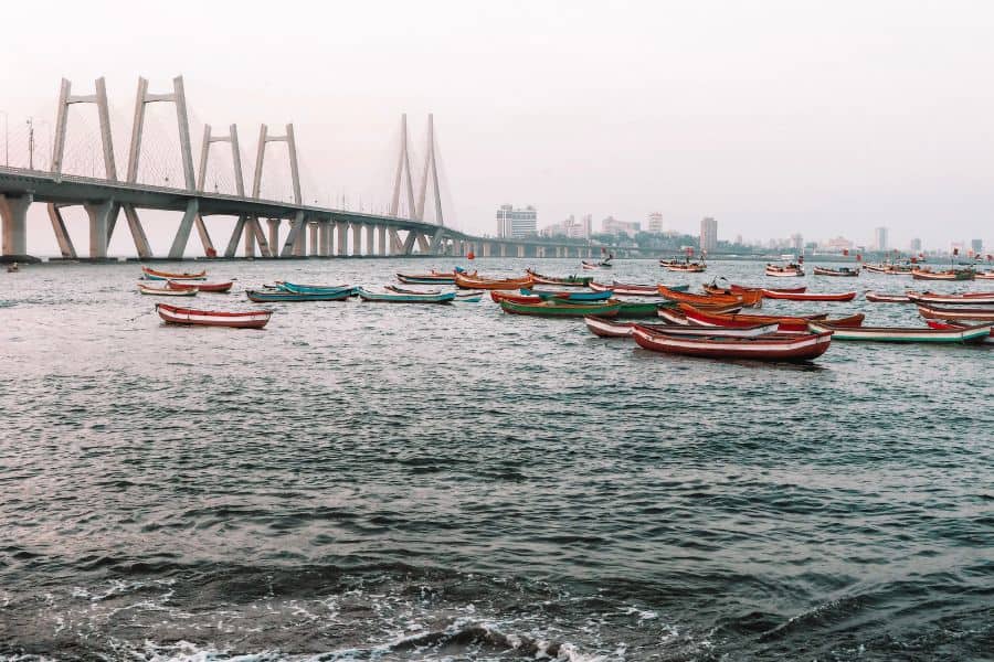 The Bandra-Worli Sea Link viewed from Worli Koliwada fishing village in Mumbai, with traditional Koli fishing boats anchored in the foreground