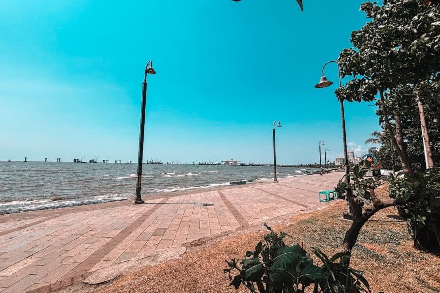 The Bandstand Promenade in Bandra West, Mumbai, a seafront walkway along the Arabian Sea with iconic lamp posts and the Bandra-Worli Sea Link in the distance