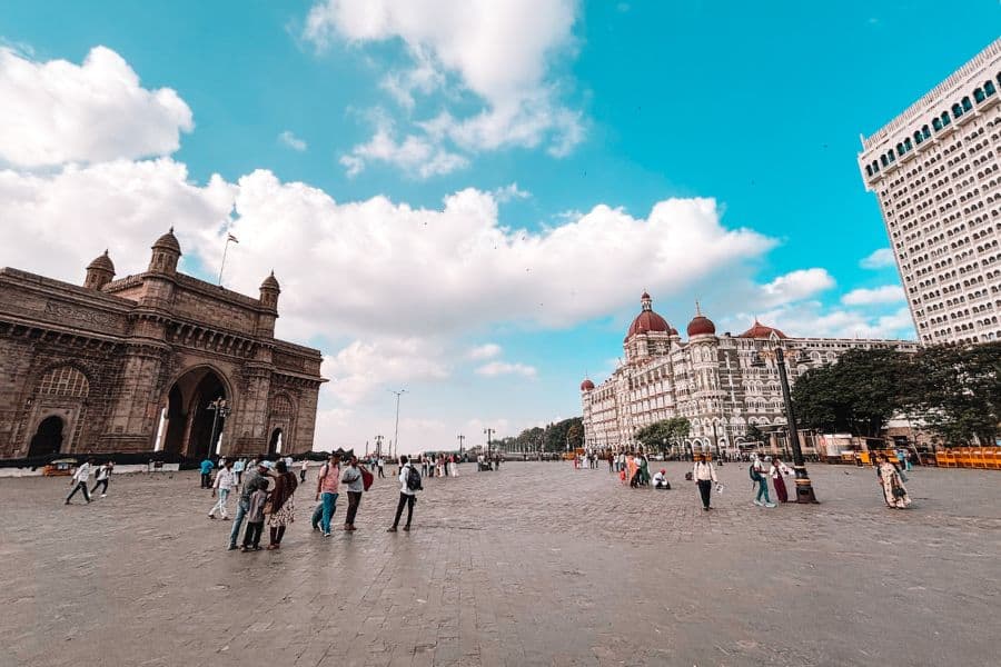 The Gateway of India arch and the Taj Mahal Palace Hotel — both Palace and Tower wings, seen across the Apollo Bunder plaza in Colaba, Mumbai's most iconic landmark setting